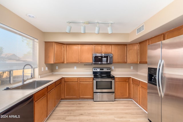 kitchen with light hardwood / wood-style floors, sink, and stainless steel appliances