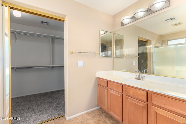 bathroom featuring vanity, tile patterned flooring, and a shower with door