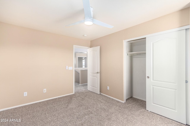 unfurnished bedroom featuring ceiling fan, a closet, and light carpet