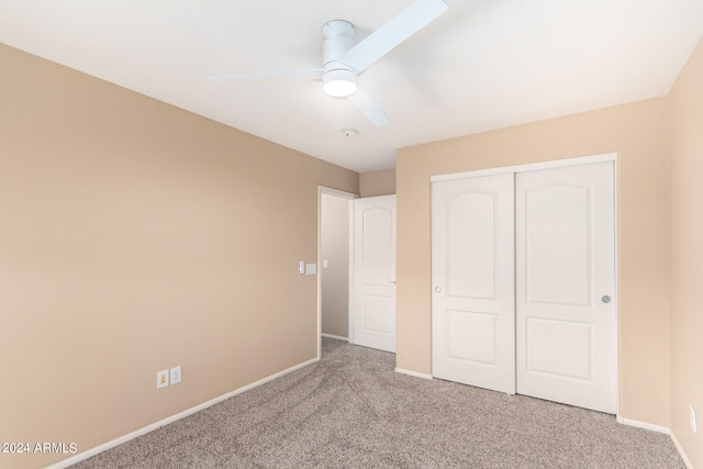 unfurnished bedroom featuring light carpet, a closet, and ceiling fan