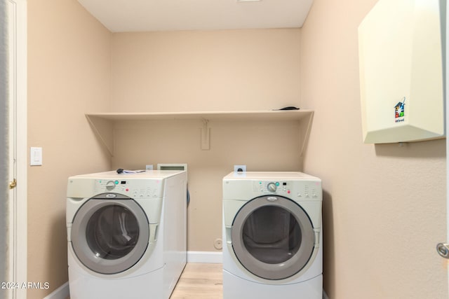 laundry room featuring washer and dryer and light hardwood / wood-style flooring