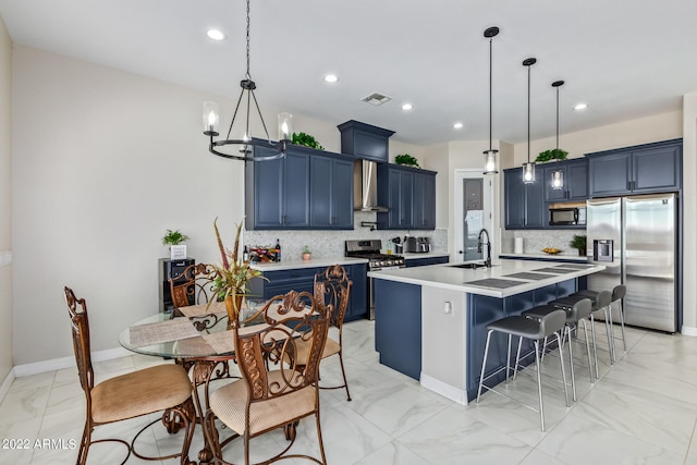 kitchen featuring backsplash, wall chimney exhaust hood, stainless steel appliances, and a center island with sink