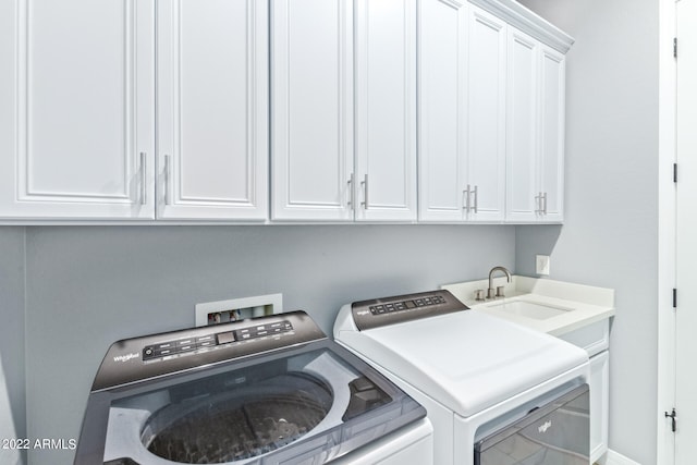 laundry room featuring sink, washing machine and dryer, cabinets, and hookup for a washing machine