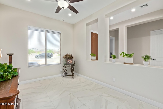 tiled empty room featuring ceiling fan