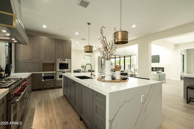 2315 E Mine Creek Rd, Phoenix, AZ 85024 - kitchen with a sink, stainless steel appliances, light wood-style flooring, recessed lighting, and wall chimney range hood
