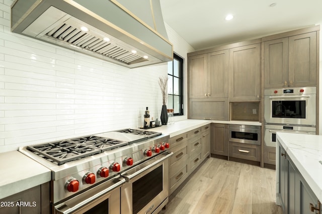 2315 E Mine Creek Rd, Phoenix, AZ 85024 - kitchen with custom range hood, appliances with stainless steel finishes, tasteful backsplash, light wood-type flooring, and recessed lighting