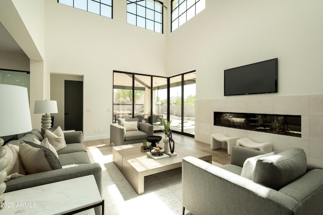 2315 E Mine Creek Rd, Phoenix, AZ 85024 - living room featuring wood finished floors, a towering ceiling, healthy amount of natural light, a tile fireplace, and baseboards
