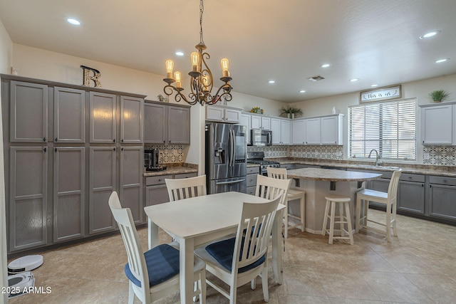 dining room with a chandelier, light tile patterned flooring, visible vents, and recessed lighting