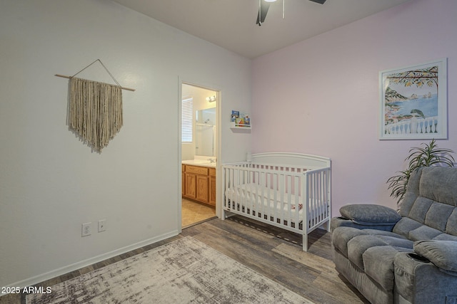 bedroom featuring a ceiling fan, baseboards, wood finished floors, and ensuite bathroom