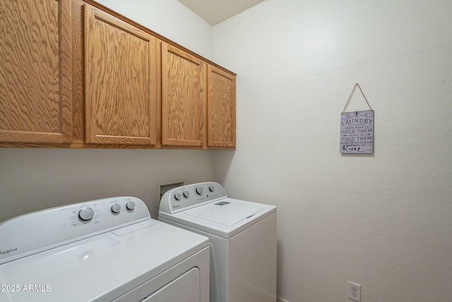 washroom with washing machine and dryer and cabinet space