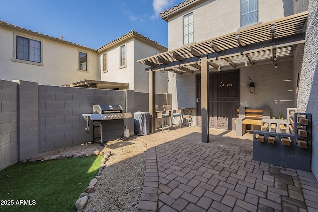 view of patio with a grill, fence, and a pergola