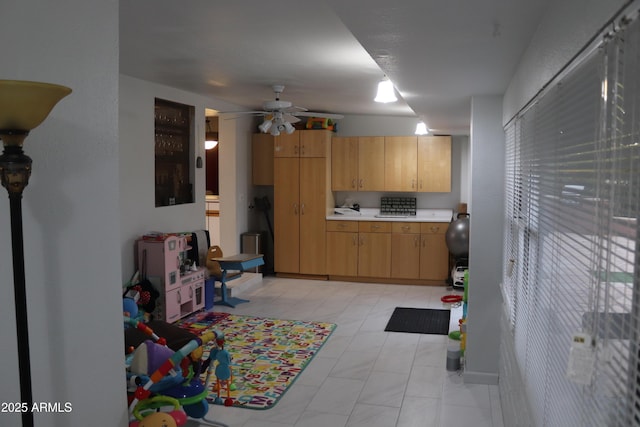 kitchen featuring light brown cabinets, ceiling fan, and light countertops
