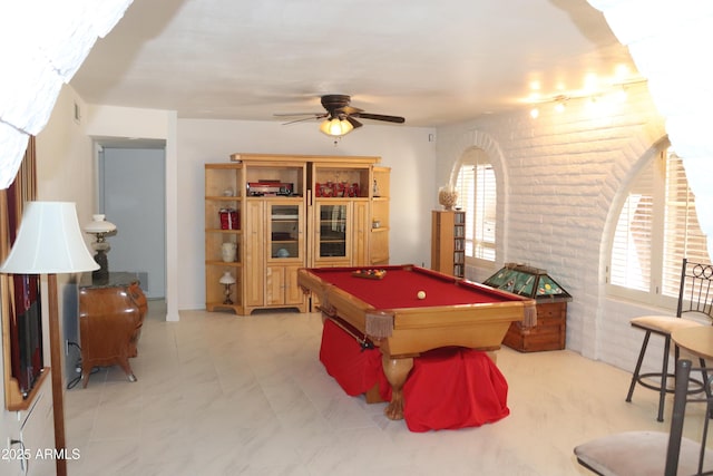 rec room with brick wall, a ceiling fan, and billiards