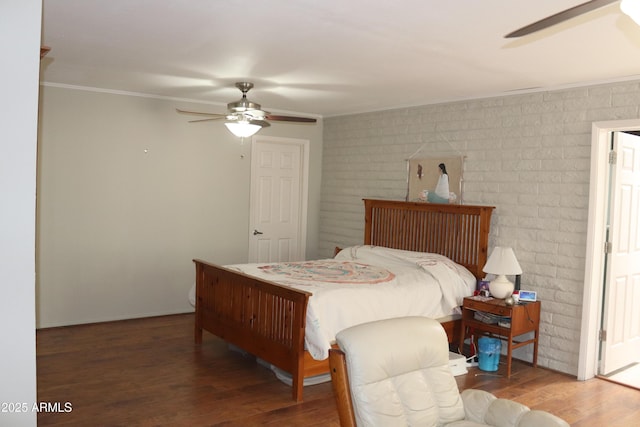 bedroom featuring brick wall, wood finished floors, ceiling fan, and crown molding