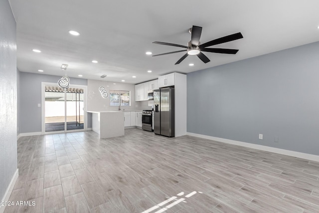 kitchen featuring white cabinetry, ceiling fan, hanging light fixtures, light hardwood / wood-style floors, and appliances with stainless steel finishes