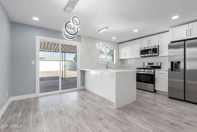 kitchen with kitchen peninsula, white cabinets, and stainless steel appliances