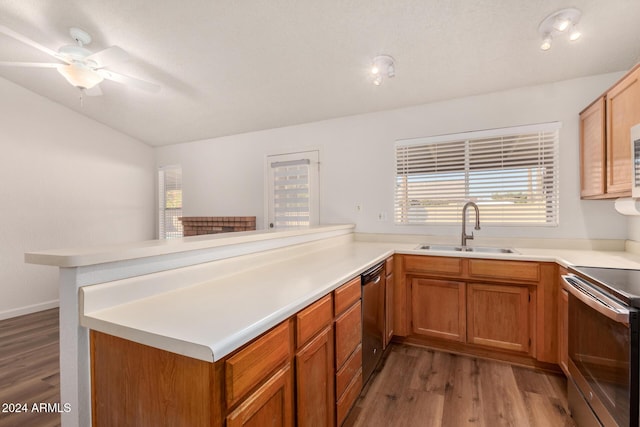 kitchen featuring ceiling fan, sink, stainless steel appliances, dark wood-type flooring, and kitchen peninsula