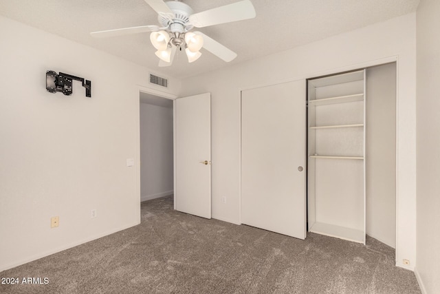 unfurnished bedroom with ceiling fan, a closet, and dark colored carpet