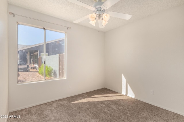 spare room featuring carpet, a textured ceiling, and ceiling fan