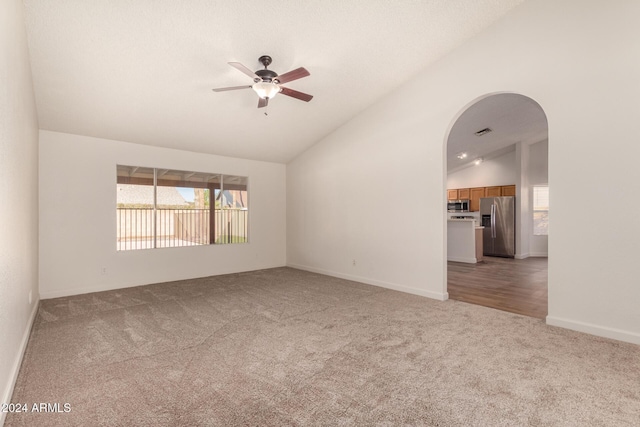 spare room featuring carpet flooring, vaulted ceiling, and ceiling fan