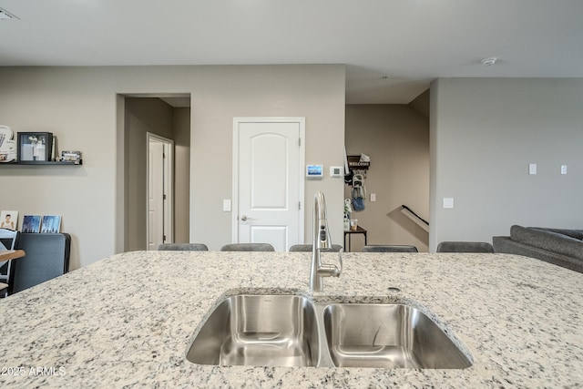 kitchen featuring light stone countertops and sink