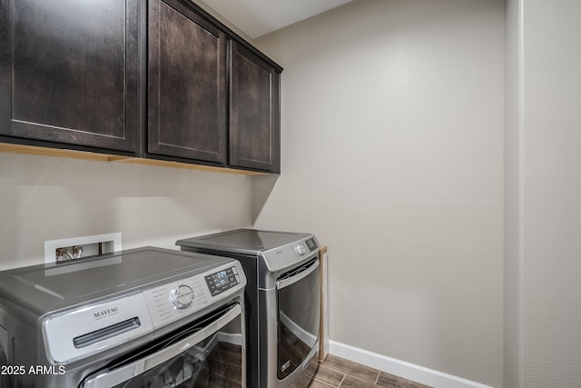 washroom with washing machine and clothes dryer and cabinets