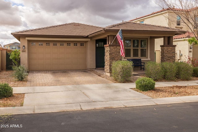 view of front of property featuring stucco siding, decorative driveway, stone siding, covered porch, and an attached garage