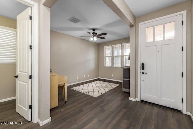 foyer entrance with dark wood-type flooring, baseboards, visible vents, and ceiling fan