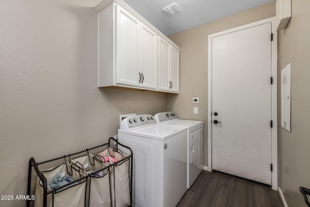 clothes washing area with washer and clothes dryer, cabinet space, baseboards, and dark wood-style flooring