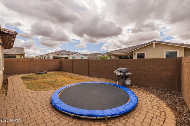 exterior space with a patio area, a trampoline, and a fenced backyard