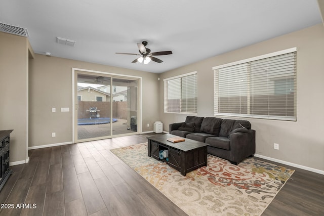 living area with dark wood finished floors, baseboards, and visible vents