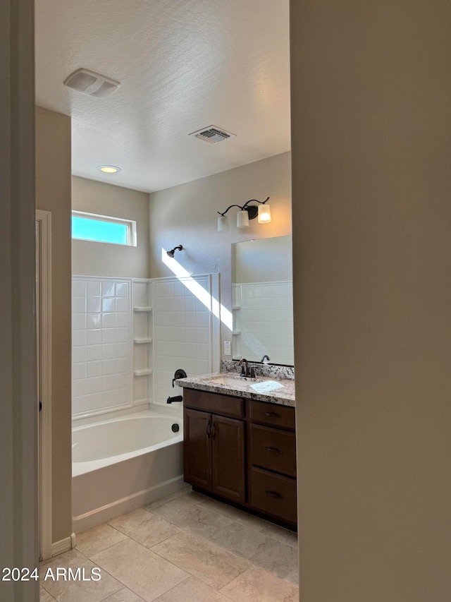 bathroom with a textured ceiling,  shower combination, tile patterned floors, and vanity