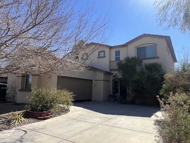 view of front of home with concrete driveway, an attached garage, and stucco siding