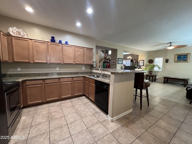 kitchen with stainless steel electric stove, a sink, dishwasher, a peninsula, and a kitchen breakfast bar