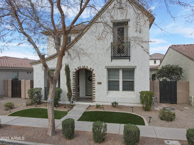 view of front of property featuring a gate, fence, and stucco siding