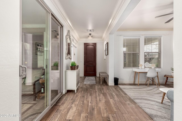 foyer entrance featuring baseboards, visible vents, ornamental molding, and wood finished floors