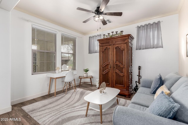 living area with ornamental molding, baseboards, and wood finished floors