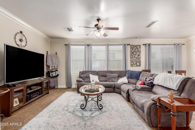 carpeted living area featuring baseboards, ornamental molding, visible vents, and a ceiling fan