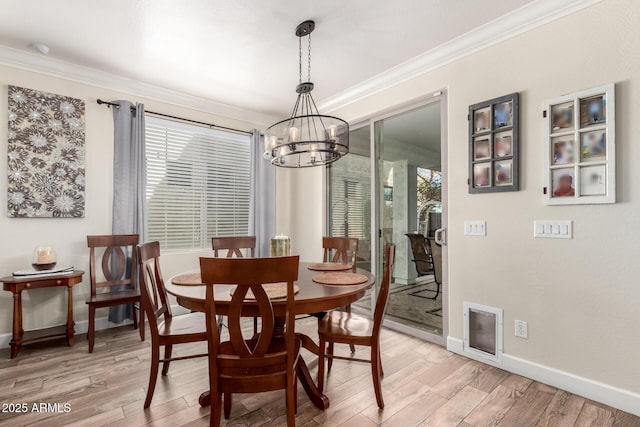 dining room featuring ornamental molding, light wood-type flooring, and a healthy amount of sunlight