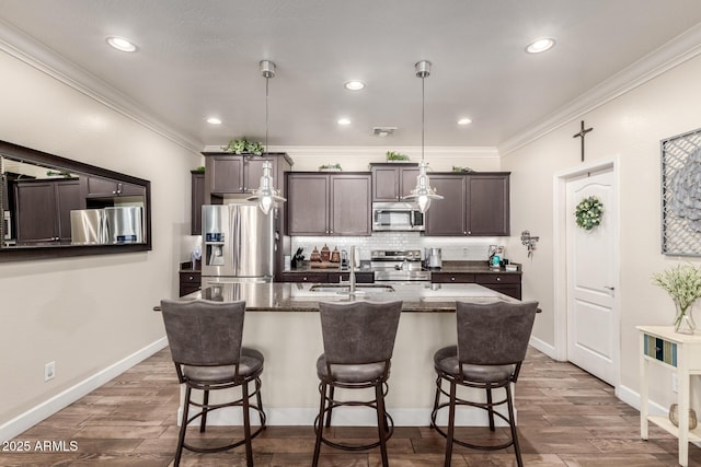 kitchen featuring dark brown cabinetry, stainless steel appliances, a breakfast bar, wood tiled floor, and tasteful backsplash