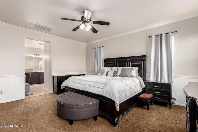 bedroom featuring light carpet, a wainscoted wall, and visible vents