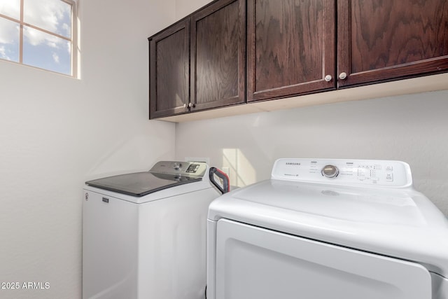 washroom featuring independent washer and dryer and cabinet space