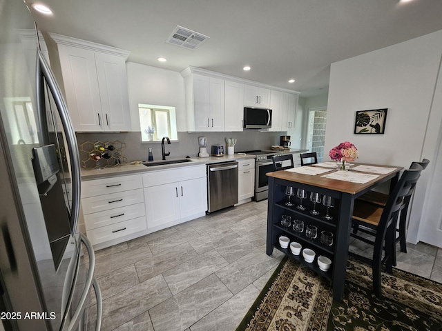 kitchen with visible vents, recessed lighting, white cabinetry, a sink, and appliances with stainless steel finishes