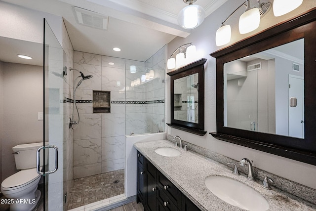 bathroom featuring an enclosed shower, vanity, crown molding, and toilet