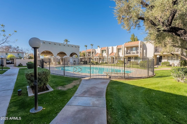 view of pool featuring a lawn