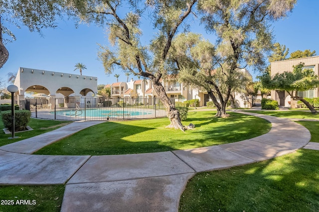 view of community featuring a swimming pool and a yard