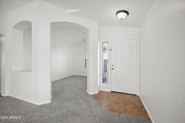 carpeted foyer entrance with lofted ceiling