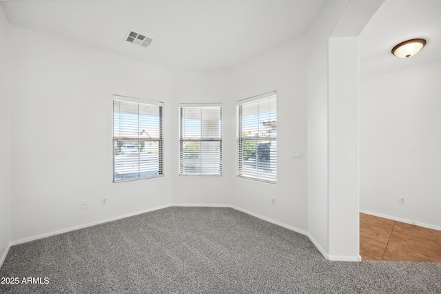 carpeted spare room featuring plenty of natural light