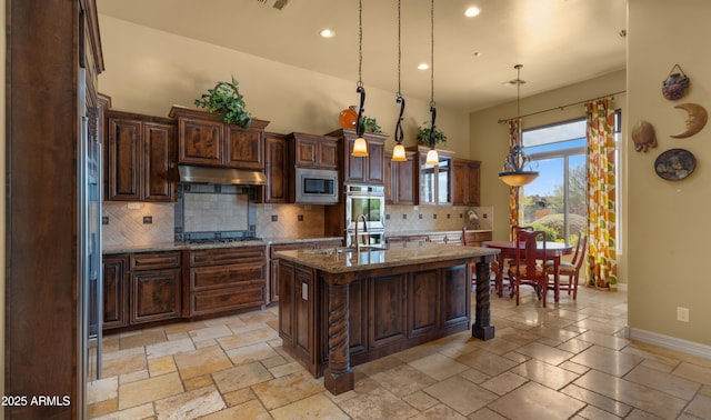 36813 N 109th Way, Scottsdale, AZ 85262 - kitchen featuring stainless steel appliances, under cabinet range hood, tasteful backsplash, light stone counters, and a center island with sink