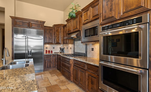 36813 N 109th Way, Scottsdale, AZ 85262 - kitchen featuring built in appliances, backsplash, light stone countertops, under cabinet range hood, and stone tile floors